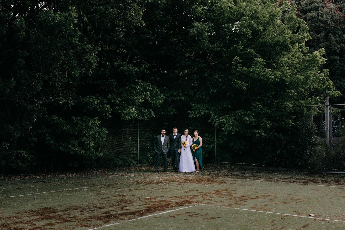 bridal party creative photos on old tennis court at bridgewater country estate venue in Kaukapakapa, Auckland photo by sarah weber photography
