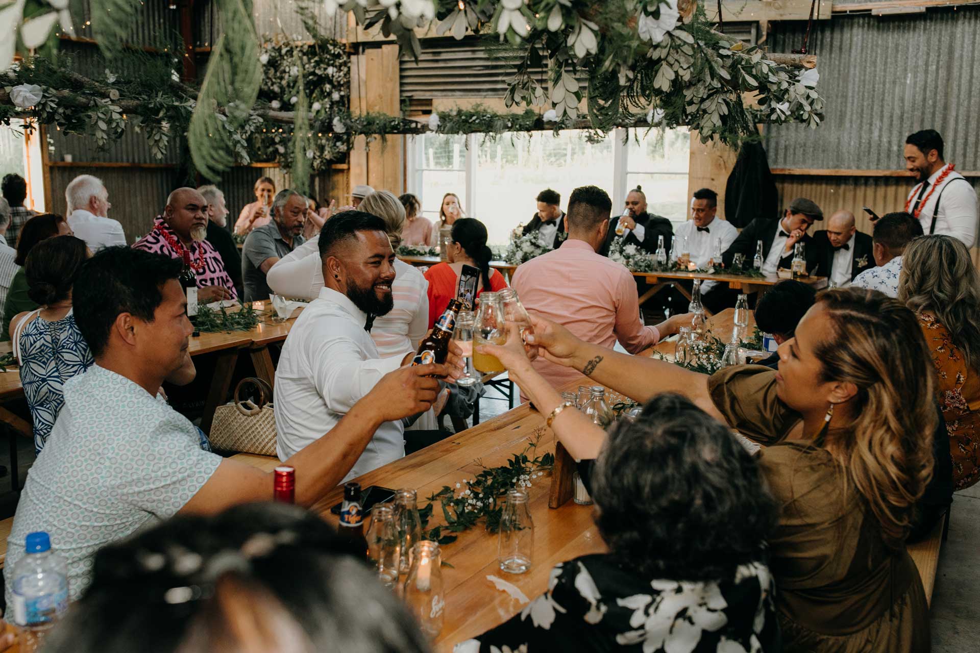 wedding guests at rustic DIY barn reception in west auckland photos by sarah weber photography